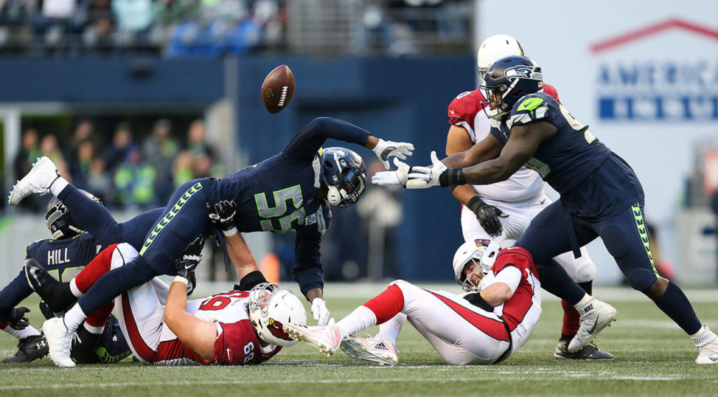 Seattle’s Quinton Jefferson (right) dives for the ball with teammate Frank Clark as Arizona quarterback Josh Rosen goes down during the Seahawks’ 27-24 win over Arizona on Sunday at CenturyLink Field in Seattle. (Andy Bronson / The Herald)
