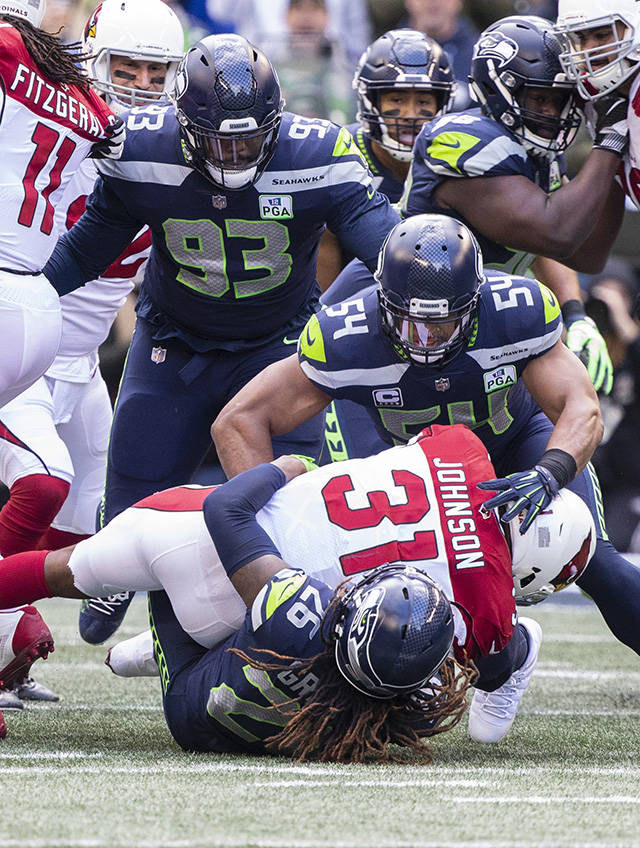 Seattle’s Shaquill Griffin (26) and Bobby Wagner (54) tackle Arizona’s David Johnson (31) behind the line of scrimmage during the Seahawks’ 27-24 win over Arizona on Sunday at CenturyLink Field in Seattle. (TJ Mullinax / For the Herald)
