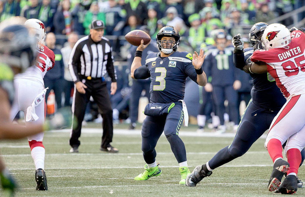 Seattle’s Russell Wilson throws a touchdown pass to Tyler Lockett in the first quarter of the Seahawks’ 27-24 win over Arizona on Sunday at CenturyLink Field in Seattle. (TJ Mullinax / For the Herald)
