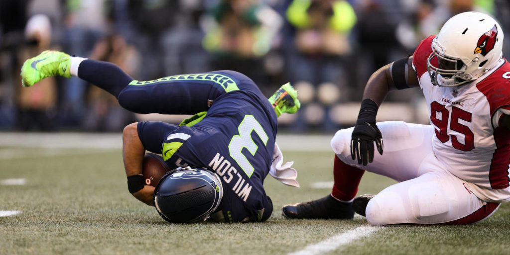 Seattle’s Russell Wilson is sacked by Arizona’s Rodney Gunter during the Seahawks’ 27-24 win over Arizona on Sunday at CenturyLink Field in Seattle. (Andy Bronson / The Herald)
