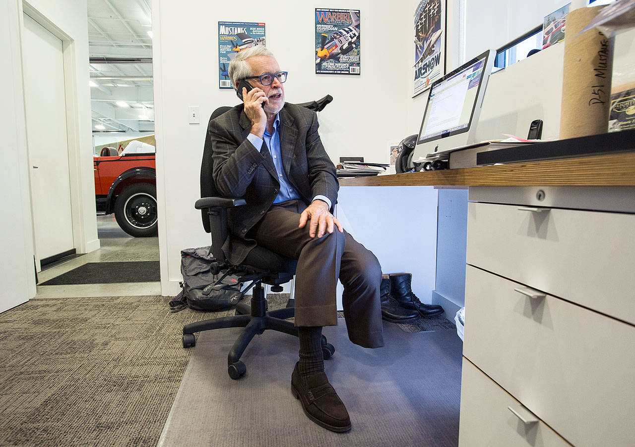 Historic Flight Foundation Chairman John Sessions takes a call in his office with his prosthetic leg in a backpack behind him. He said he was giving his leg a rest after “overdoing the day before.” (Andy Bronson / The Herald)