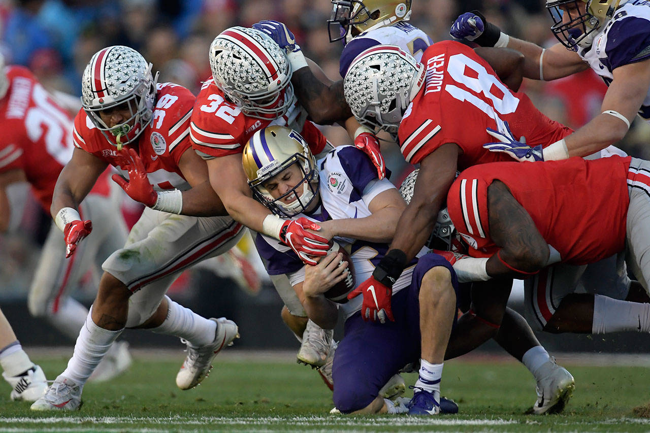 Washington quarterback Jake Browning is sacked by Ohio State defenders during the Rose Bowl on Jan. 1, 2019, in Pasadena, Calif. (AP Photo/Mark J. Terrill)