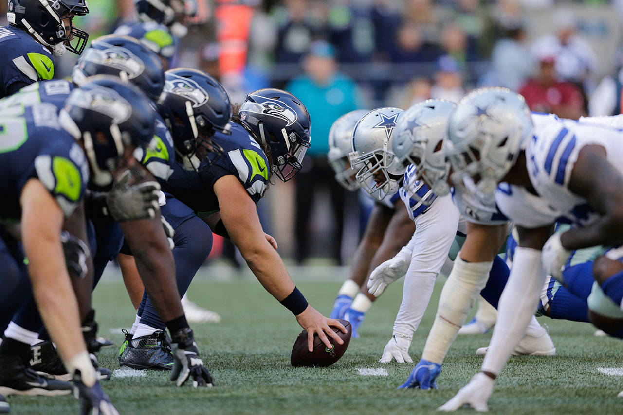 Seattle Seahawks and Dallas Cowboys players line up on the line of scrimmage during the second half of an NFL football game on Sept. 23, 2018, in Seattle. (AP Photo/John Froschauer, file)