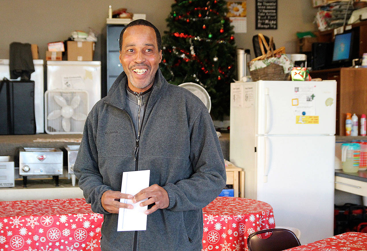 James Parham accepts his check after successfully reciting Hamlet’s fourth soliloquy from memory for the Hamlet Challenge at Spin Cafe. (Laura Guido / Whidbey News-Times)