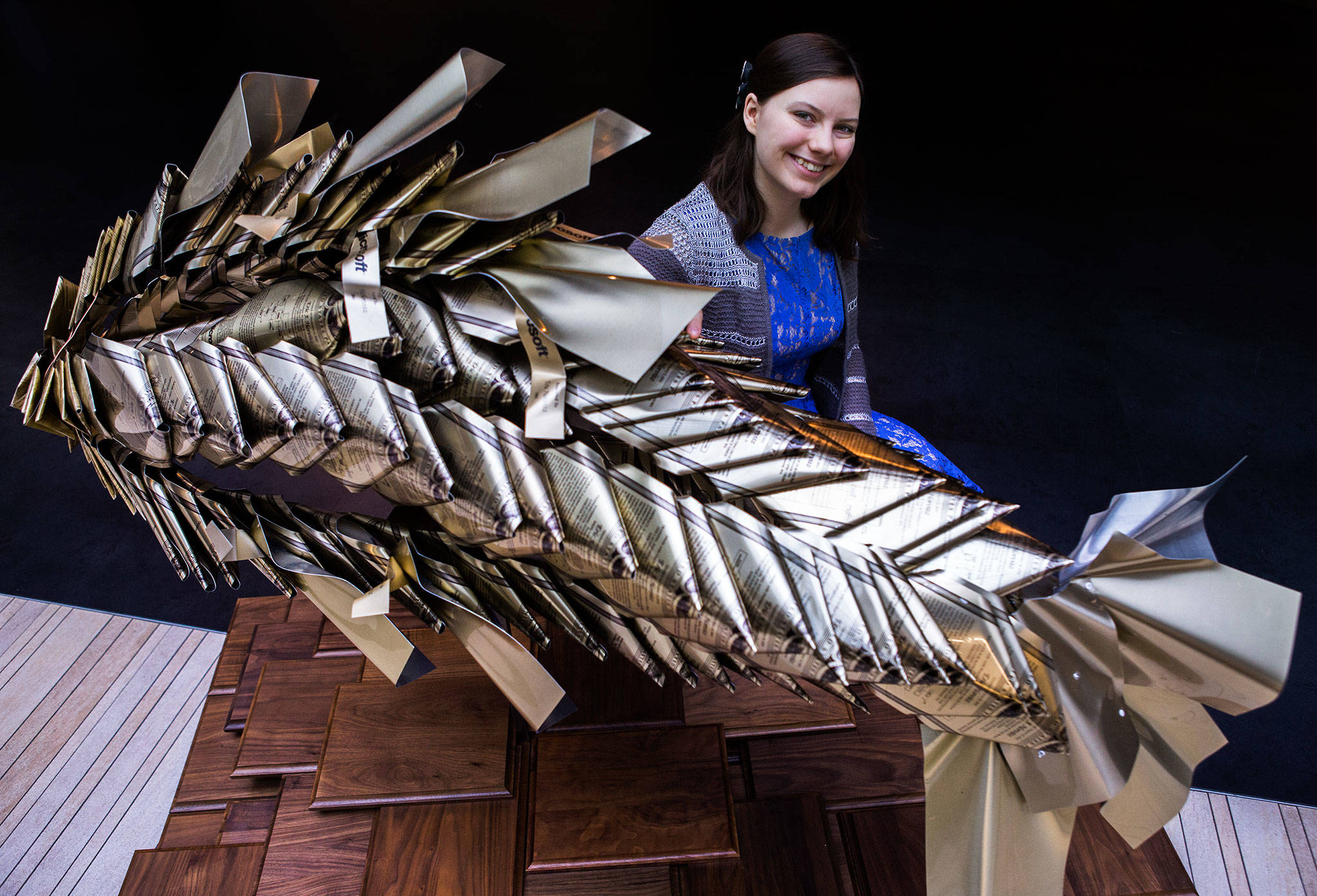 Charlotte Day next to her Patent No. 1 sculpture made of upcycled Microsoft Patent plaques Thursday at the Microsoft Campus in Redmond. (Olivia Vanni / The Herald)