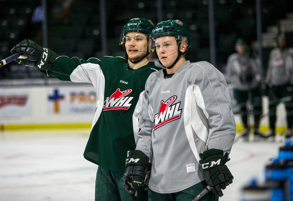 Zack Andrusiak (left) talks with teammate Jackson Berezowski (right) during Silvertips practice Wednesday in Everett. (Olivia Vanni / The Herald)
