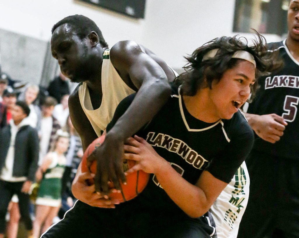 Lakewood&rsquo;s Morgan Stacey is fouled by Marysville Getchell&rsquo;s Lul William during a non-conference game Wednesday in Marysville. Stacey and the Cougars beat William and the Chargers 62-54. (Kevin Clark / The Herald)
