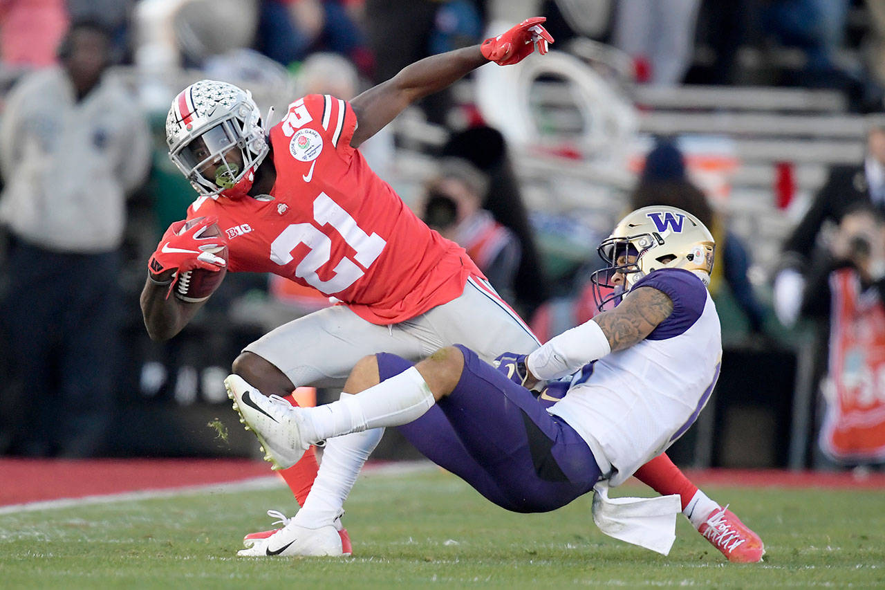 Washington’s Brandon McKinney (right) tackles Ohio State’s Parris Campbell during the first half of Tuesday’s Rose Bowl game in Pasadena, California. (AP Photo/Mark J. Terrill)