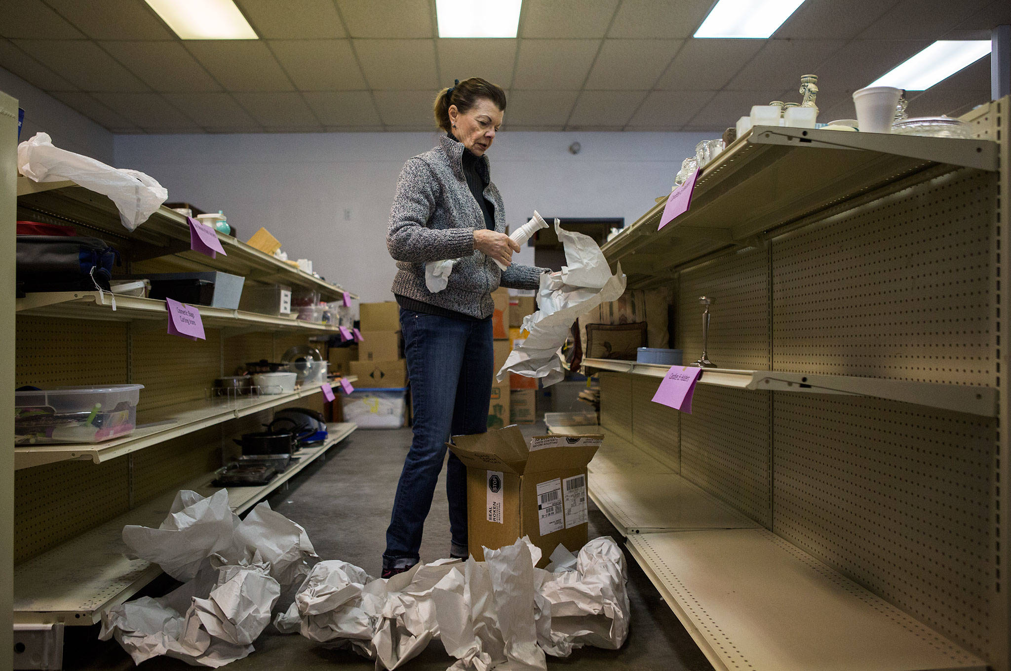 Marilyn Nadeau helps unpack donation boxes at the Edmonds Senior Center’s new thrift store. The store will have a soft opening on Jan. 16 and a grand opening on Jan. 19. (Olivia Vanni / The Herald)