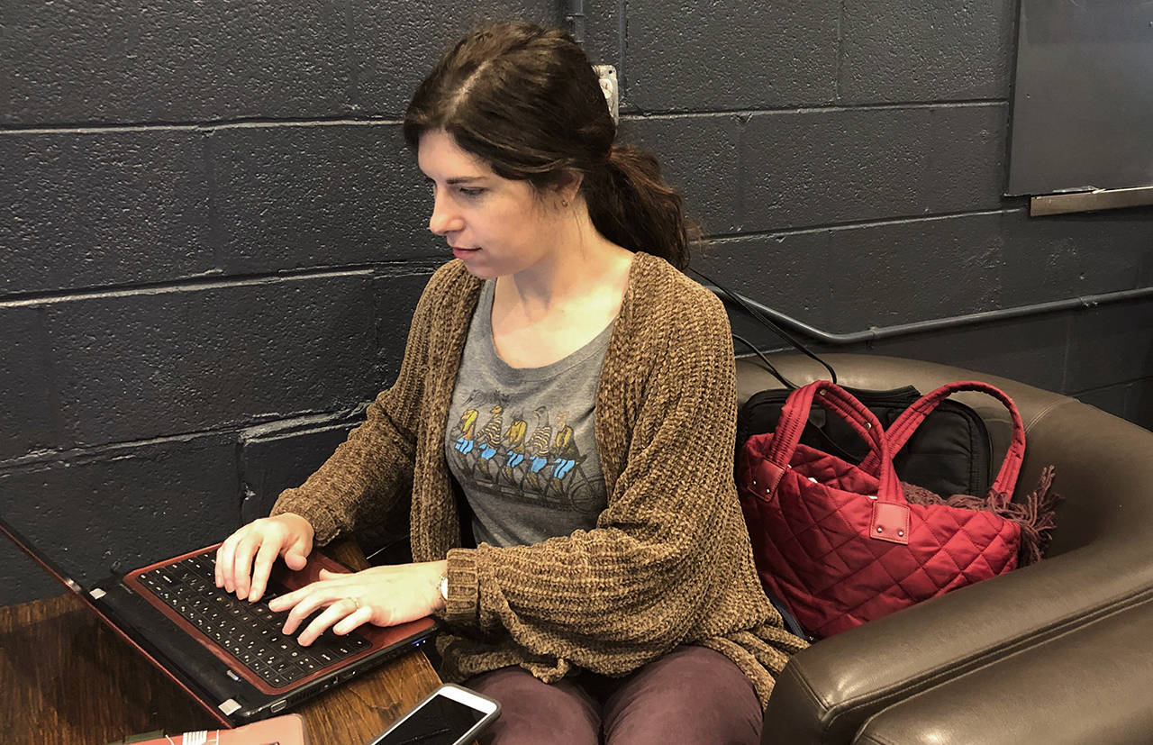 Furloughed federal worker Amanda Wagner works on a photo album at a coffee shop in Silver Spring, Maryland, on Thursday. Unable to go to work, she spent the morning at the coffee shop offering free drinks to furloughed federal works. (AP Photo/Michael Kunzelman)