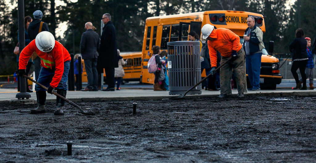 As students arrive Monday at the new Madrona K-8 School in Edmonds, work continues on the landscaping. (Dan Bates / The Herald)
