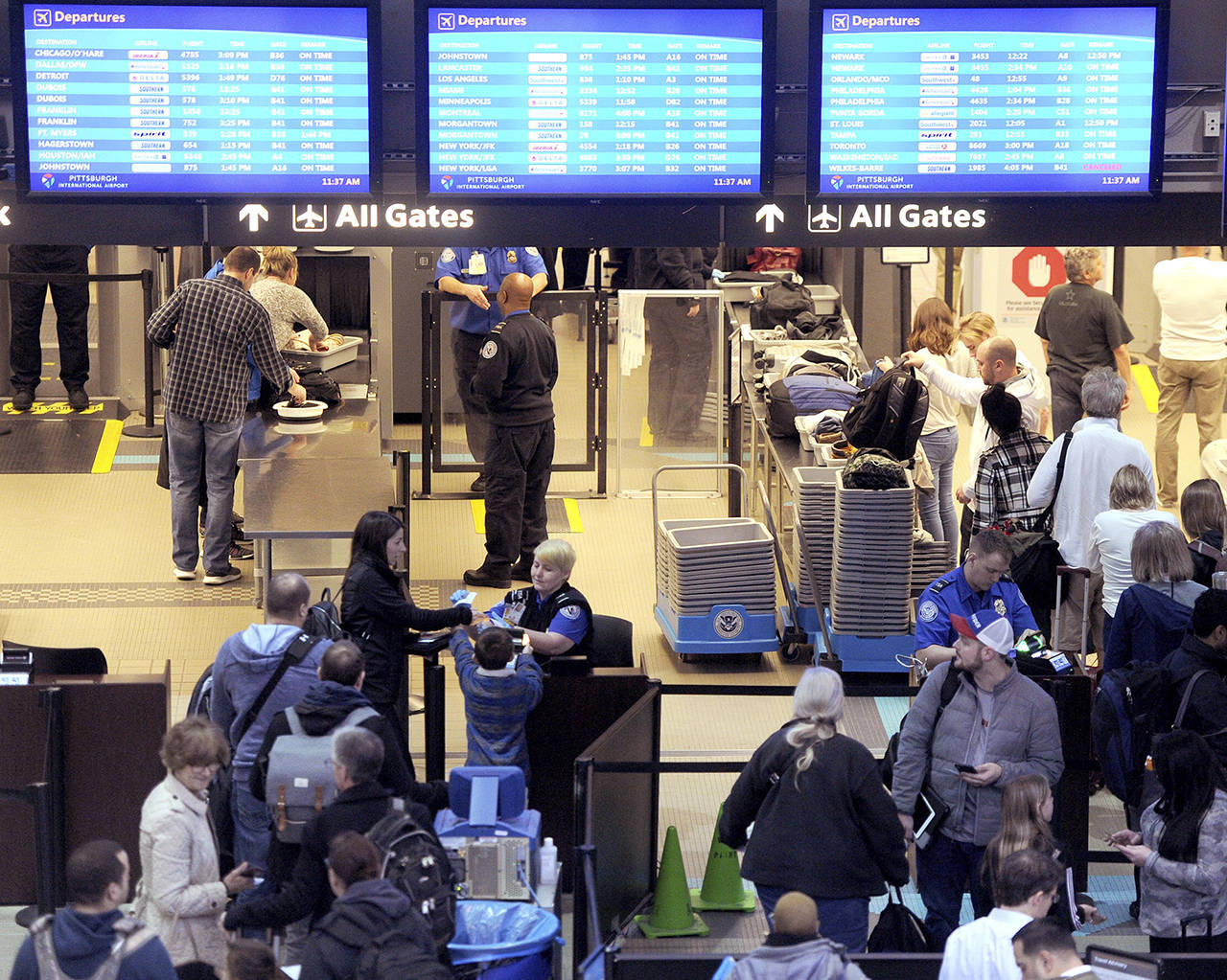 Transportation Security Administration security officers check passengers through security at the Pittsburgh International Airport on Thursday in Pittsburgh. As the government shutdown continues, TSA staff work without pay. (Pam Panchak/Pittsburgh Post-Gazette via AP)