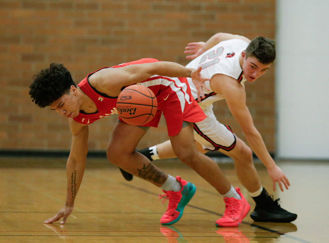 Marysville Pilchuck’s Alec Jones-Smith (left) is spun around by Mountlake Terrace’s Trazz Pepper during a battle for a loose ball during a Wesco 3A game Monday in Mountlake Terrace. Jones-Smith and the Tomahawks beat Pepper and the Hawks 51-42. (Andy Bronson / The Herald)