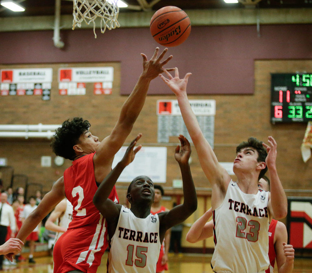 Marysville Pilchuck’s Alec Jones-Smith (left) battles Mountlake Terrace’s Jeffrey Anyimah (15) and Robbie Baringer for a rebound during a Wesco 3A game Monday in Mountlake Terrace. Jones-Smith and the Tomahawks won 51-42. (Andy Bronson / The Herald)
