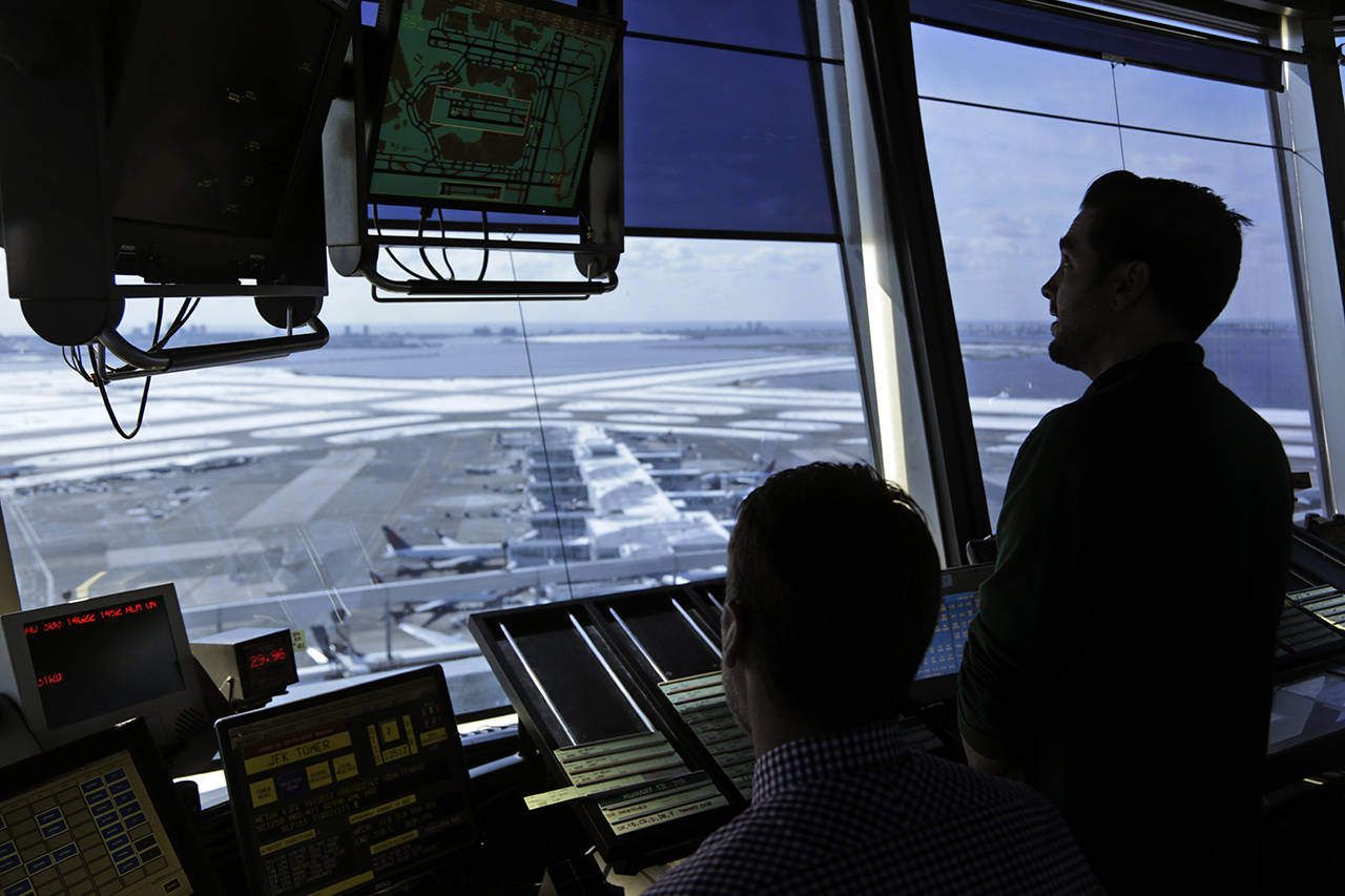 In this 2017 photo, air traffic controllers work in the tower at John F. Kennedy International Airport in New York. The partial government shutdown is starting to effect air travelers. (AP Photo/Seth Wenig, File)