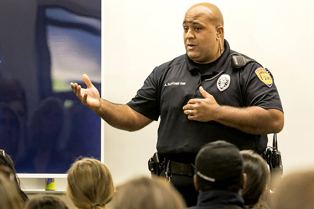 Officer Anthony Fletcher addresses the audience at a public meeting about gangs in September 2018 at Explorer Middle School in Everett. (Kevin Clark / The Herald)