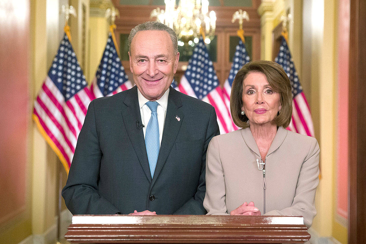 Senate Minority Leader Chuck Schumer of New York and House Speaker Nancy Pelosi of California pose for photographers after speaking on Capitol Hill in response to President Donald Trump’s Oval Office address Tuesday night in Washington. (AP Photo/Alex Brandon)