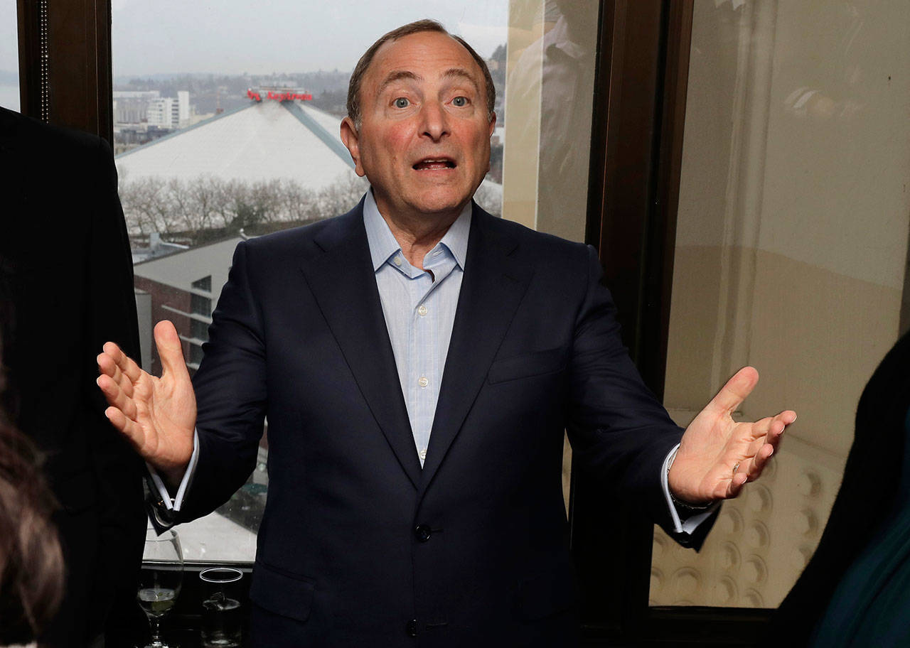 With KeyArena over his shoulder in the window at left, NHL Commissioner Gary Bettman talks to visitors on Jan. 9, 2019, at a luncheon prior to a news conference in Seattle. (AP Photo/Ted S. Warren)