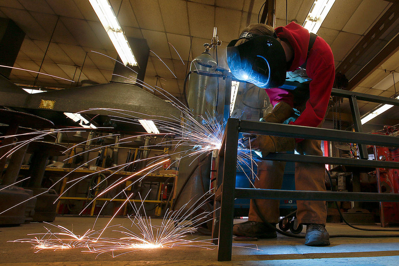 Sparks fly as a student welds a bench seat during the Country Living Expo Cattlemen’s Winterschool in 2017 at Stanwood High School. This year’s event is scheduled for Jan. 26. (Herald file)