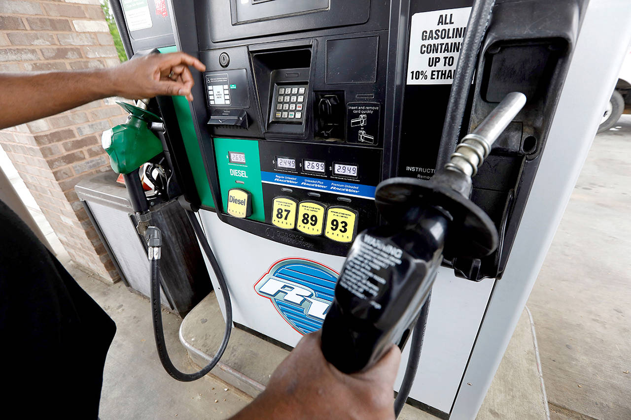 A customer prepares to make his selection among grades of fuel at the gasoline pump in Richland, Mississippi in April. Crude oil prices are at the highest level in more than three years and expected to climb higher, pushing up gasoline prices along the way. Washington state is wrapping up a pilot study that would track mileage to determine the tax paid by drivers. (Rogelio V. Solis /Associated Press file photo)