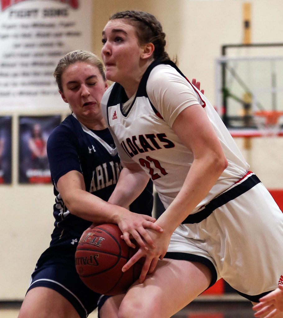 Arlington’s Hailey Hiatt (left) locks up the ball with Archbishop Murphy’s Emily Rodabaugh driving the lane during a game on Jan. 11, 2019, at Archbishop Murphy High Schoolin Everett. The Wildcats won 58-49. (Kevin Clark / The Herald)
