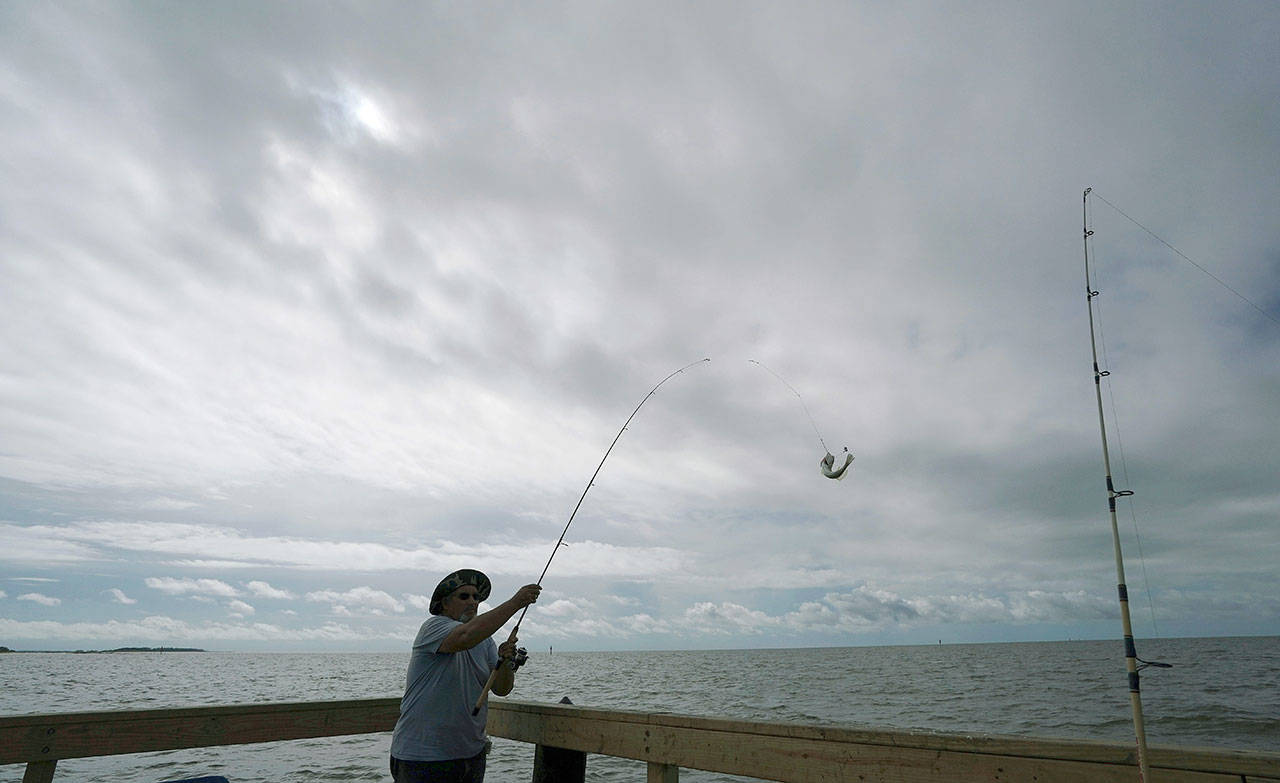 Tim Hitchens pulls in a fish while fishing from a pier in the Gulf of Mexico, the morning after Tropical Storm Gordon made landfall nearby, in Biloxi, Mississippi, on Sept. 18. The rules that govern recreational marine fishing in the U.S. will get an overhaul because of a new law passed by in December. (AP Photo/Gerald Herbert, File)