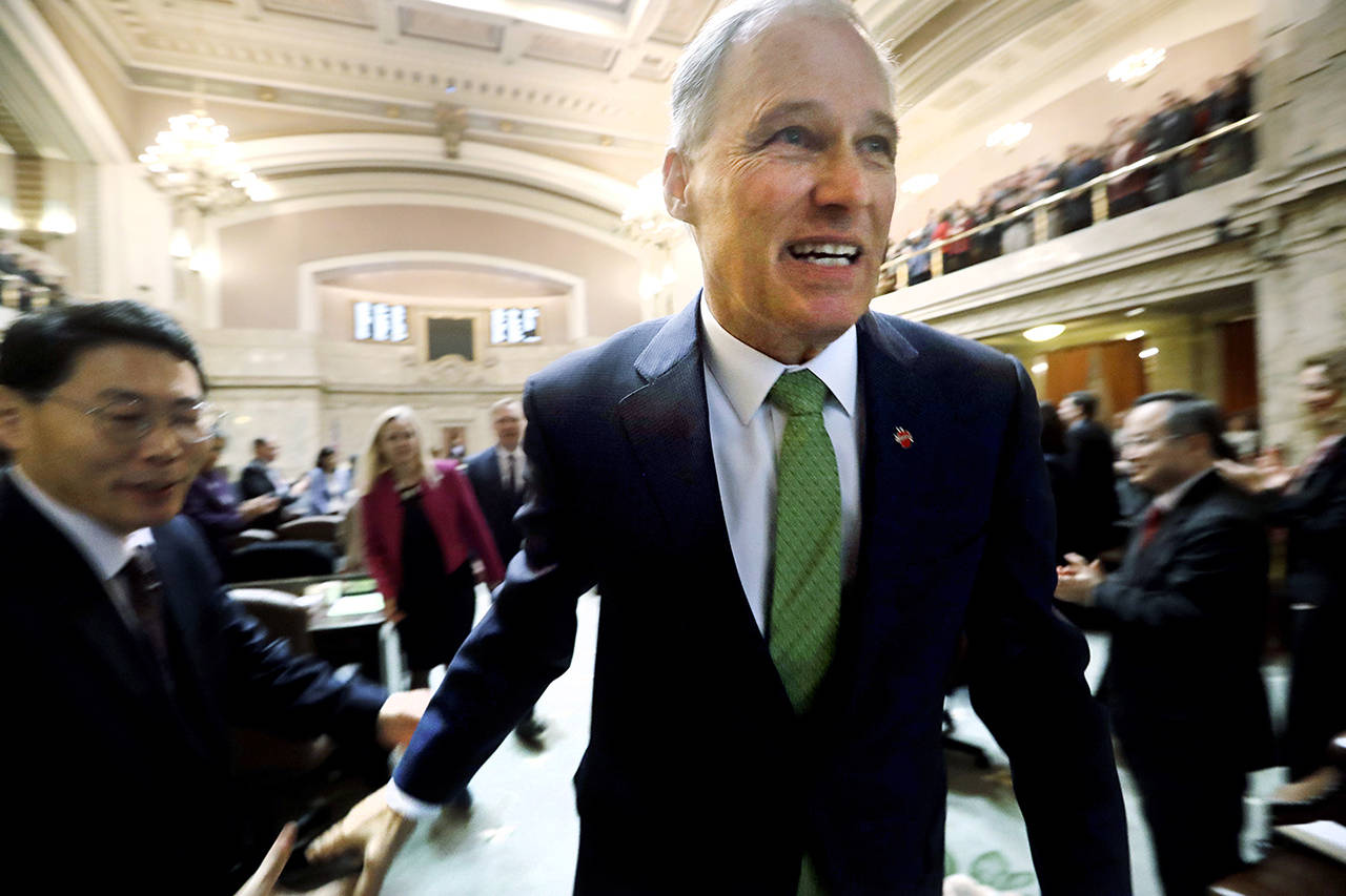 Gov. Jay Inslee heads out after giving his State of the State address to a joint session of the Legislature on Tuesday in Olympia. Inslee, who is mulling a 2020 White House bid, highlighted his clean energy agenda in the annual speech. (AP Photo/Elaine Thompson)