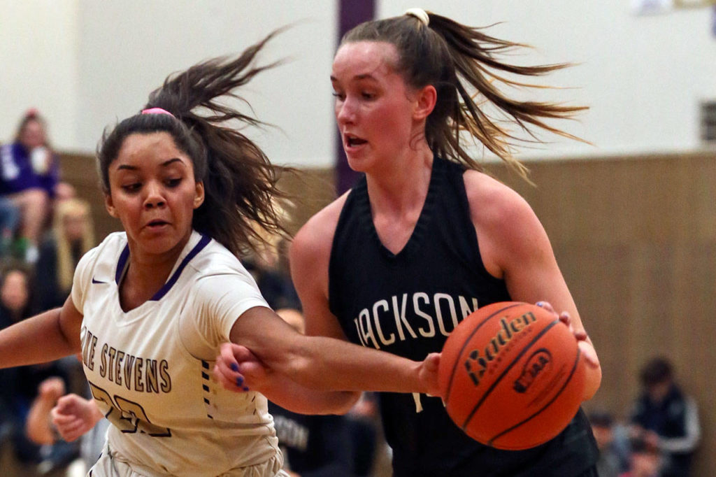Lake Stevens’ Raigan Reed (left) reaches to dislodge the ball from Jackson’s Alexa Martin during the Vikings’ 62-39 win Tuesday night at Lake Stevens High School. (Kevin Clark / The Herald)
