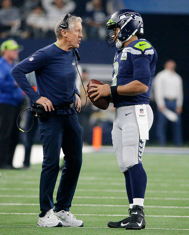 Seahawks head coach Pete Carroll speaks with quarterback Russell Wilson during the first half of an NFC wild-card playoff game against the Cowboys on Jan. 5, 2019, in Arlington, Texas. (AP Photo/Michael Ainsworth)