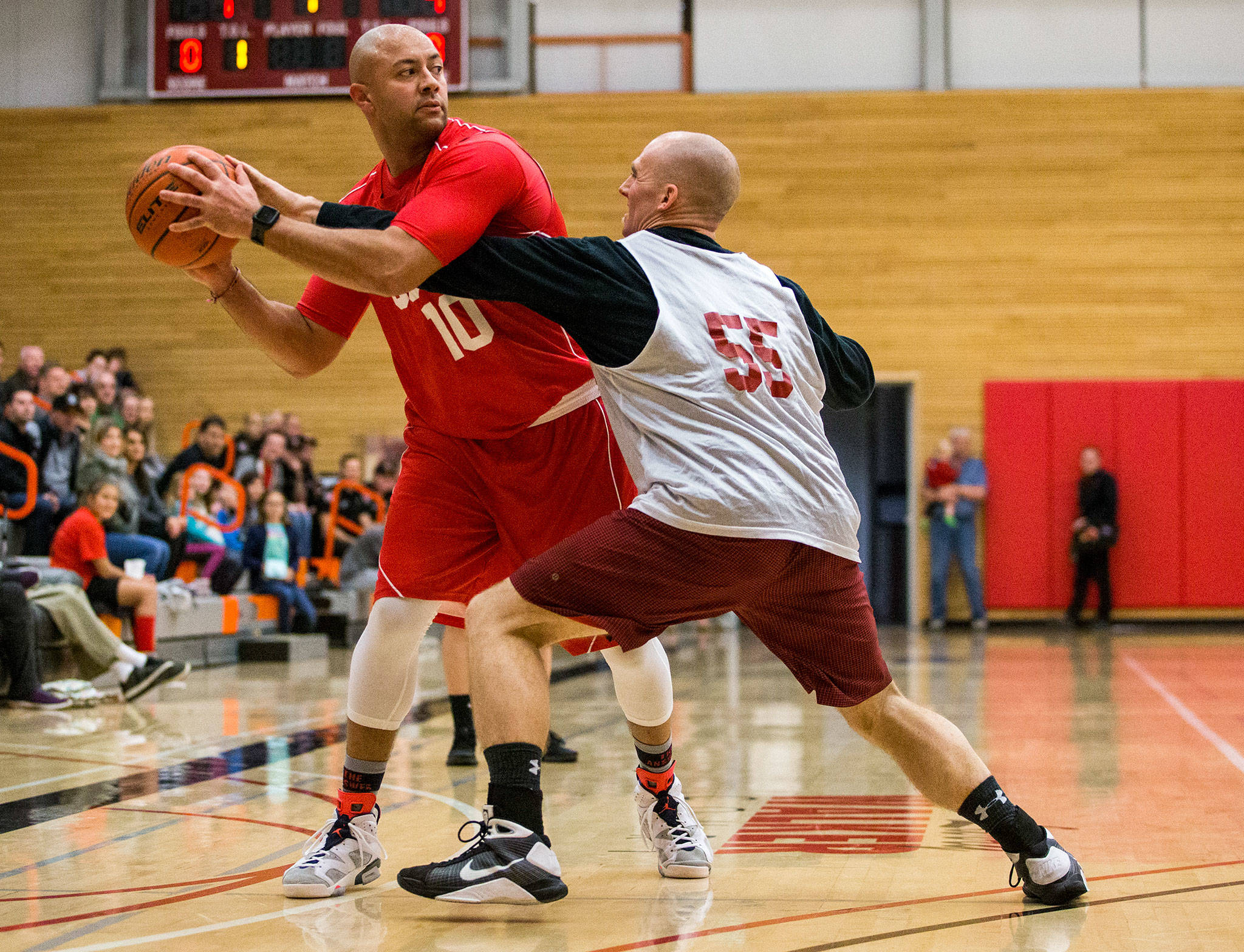 South Snohomish Fire’s Nate Crawford (left) shields the ball from Everett Fire’s Marcus Reinhard during a charity basketball game between the two fire departments on Jan. 19 at the Walt Price Student Fitness Center on the campus of Everett Community College. (Olivia Vanni / The Herald)