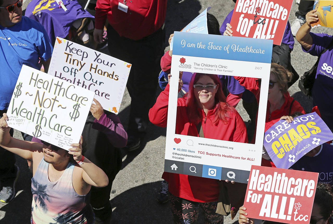 In this 2017 photo, hundreds of people march through downtown Los Angeles protesting President Donald Trump’s plan to dismantle the Affordable Care Act, his predecessor’s signature health care law. (AP Photo/Reed Saxon, File)