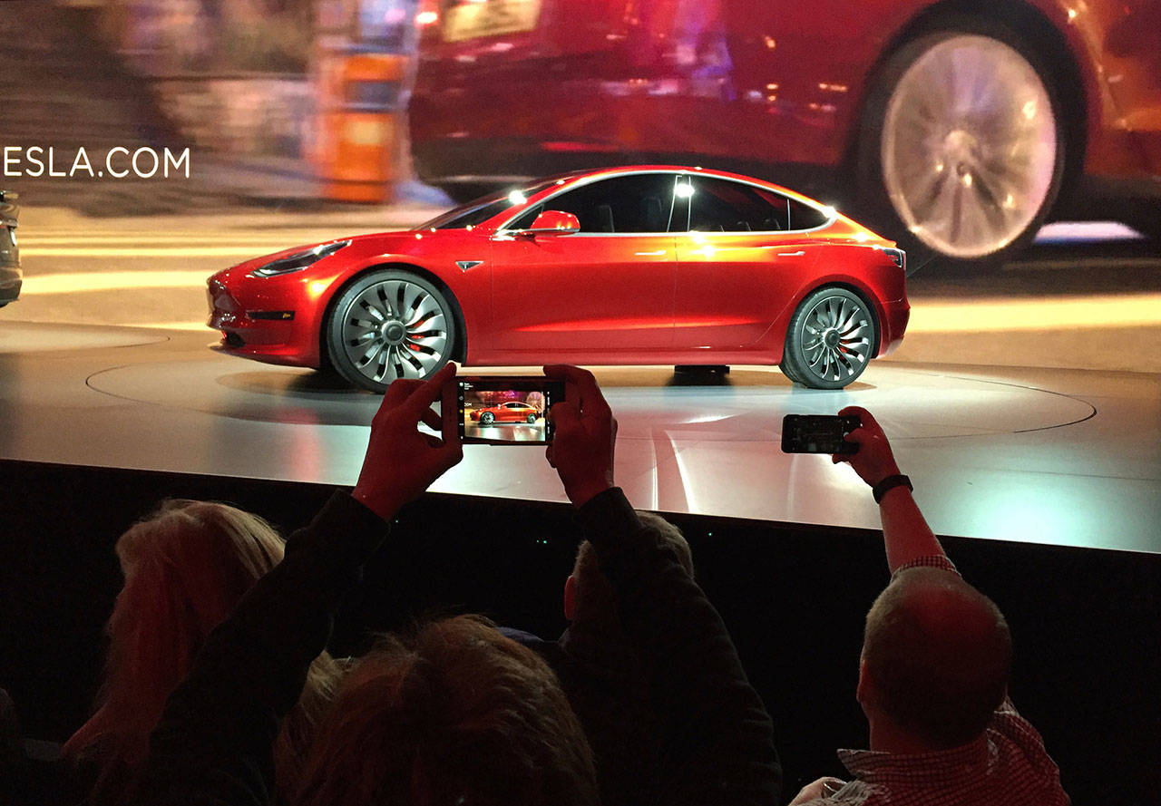 Tesla Motors unveils the new lower-priced Model 3 sedan at the Tesla Motors design studio in Hawthorne, Calif., on March 2016. Tesla, recognizing as imperative its ability to produce a cheaper electric car, told employees Friday that it must cut 7 percent of its workforce. Tesla’s cheapest model right now is the $44,000 Model 3, and it needs to broaden its customer base to survive. (AP Photo/Justin Pritchard)