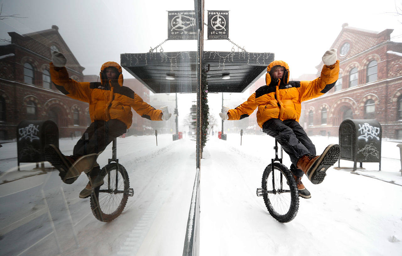 Caleb Seely rides a unicycle on a snow covered sidewalk as he heads home Sunday after helping shovel out his brother’s driveway during a winter storm Portland, Maine. The extra knobby tire on Seely’s ride provided traction on a day when snow, sleet and freezing rain kept most motorists indoors. Parts of New England residents are bracing for up to 18 inches of snow. (AP Photo/Robert F. Bukaty)