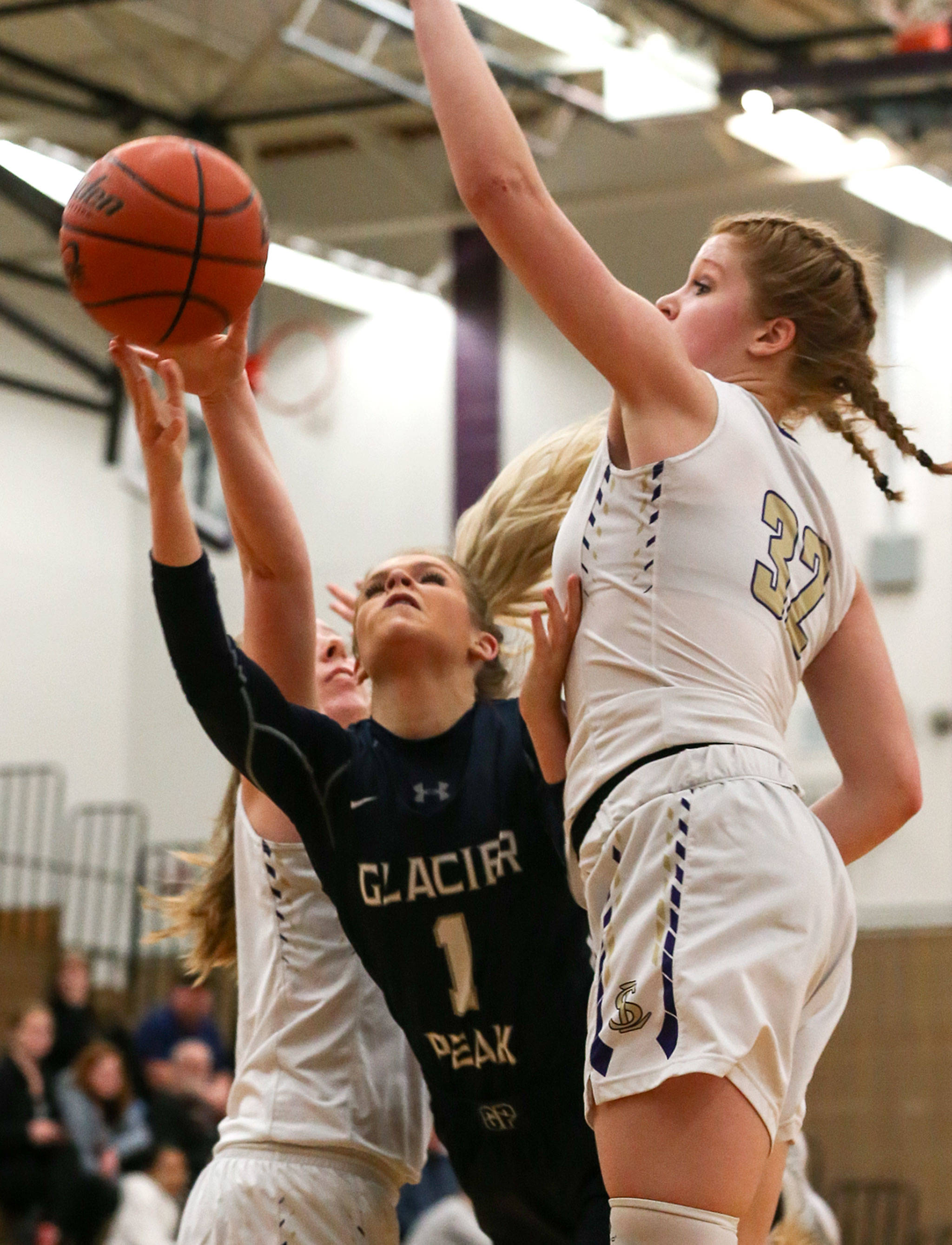 Glacier Peak’s Haley Grambo attempts a shot while splitting Lake Stevens defenders Kaylie Bracy (left) and Cori Wilcox during the Grizzlies’ 67-48 win over the Vikings on Tuesday night at Lake Stevens High School. (Kevin Clark / The Herald)