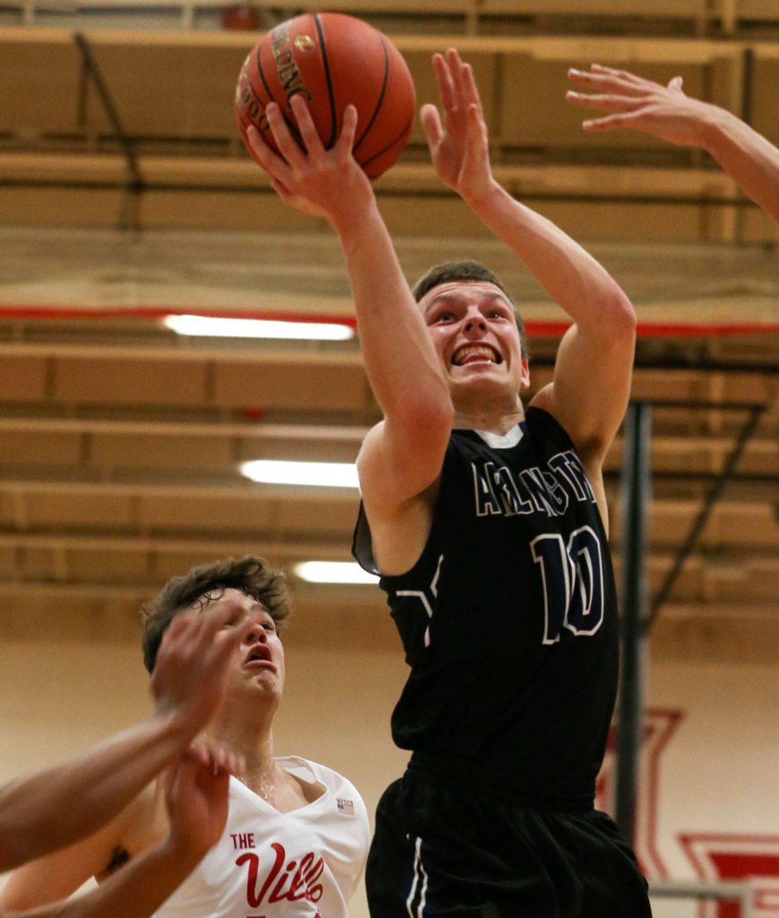 Arlington’s Anthony Whitis (10) attempts a shot as Marysville Pilchuck’s Brady Phelps looks on during a Wesco 3A boys basketball game Wednesday in Marysville. Whitis scored a game-high 21 points for the Eagles in a 60-52 loss to the Tomahawks. (Kevin Clark / The Herald)
