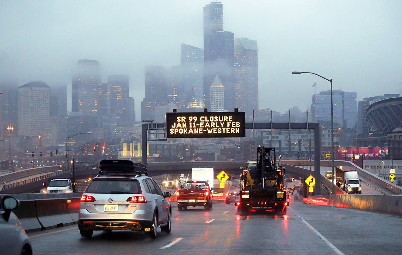 In this Jan. 3 photo, rush hour northbound Highway 99 traffic backs-up while heading toward the Alaskan Way Viaduct just ahead as a sign overhead advises of an upcoming closure of the roadway in Seattle. The double-decker highway along Seattle’s waterfront was shut down for good Jan. 11, ushering in what officials thought would be one of the most painful traffic periods in the city’s history. (AP Photo/Elaine Thompson)