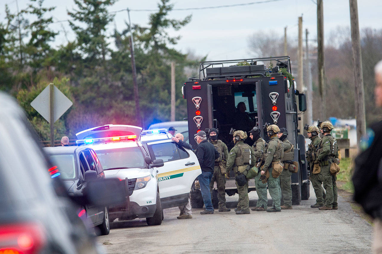 The State Patrol SWAT team gathers after serving a warrant Thursday morning that led to the arrest of a man suspected to be involved in the triple homicide discovered New Year’s Eve. (Jesse Major / Peninsula Daily News)