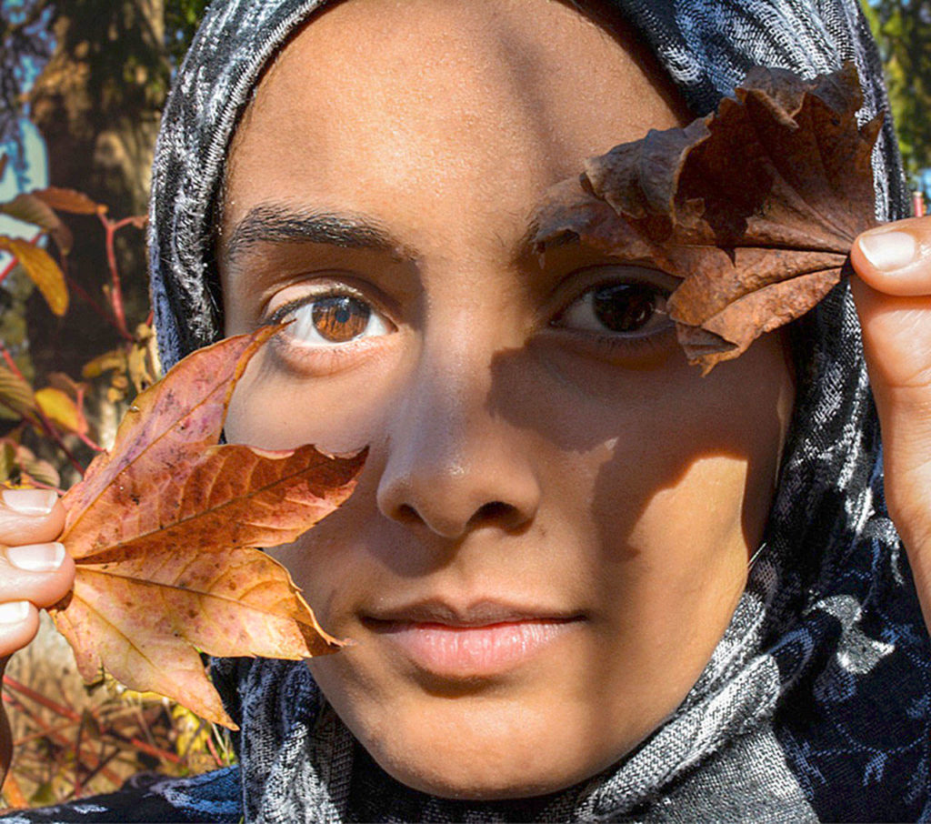 Trail family, first place: This photo by Sidney Spencer-Mylet shows her hiking friend, Ruwida, framing her face with fall leaves. It won her first place in the Trail Family category.
