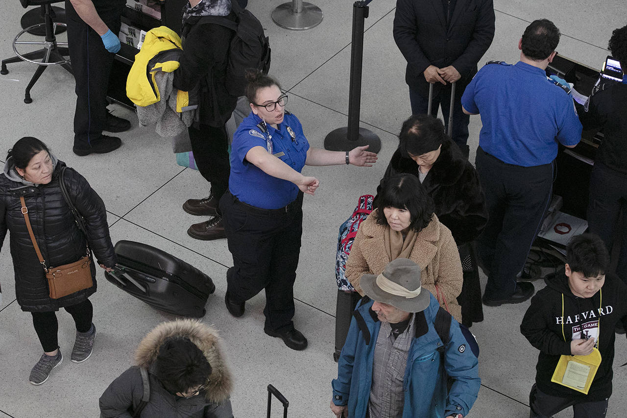 A TSA agent directs passengers through a security checkpoint at New York’s John F. Kennedy International Airport on Jan. 7. (AP Photo/Mark Lennihan, File)