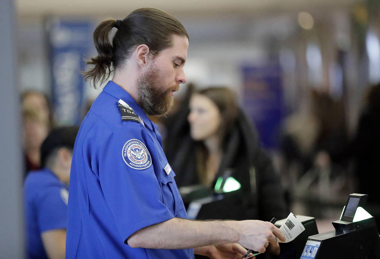 Passengers stand in line as they wait to pass through a TSA security checkpoint at LaGuardia airport on Jan. 7 in New York. (AP Photo/Frank Franklin II)