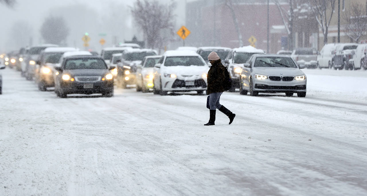 A pedestrian crosses a road in Madison, Wisconsin, on Jan. 23. A new report is calling on federal, state and local governments to do more to address a spike in pedestrian fatalities. (Steve Apps/Wisconsin State Journal via AP)