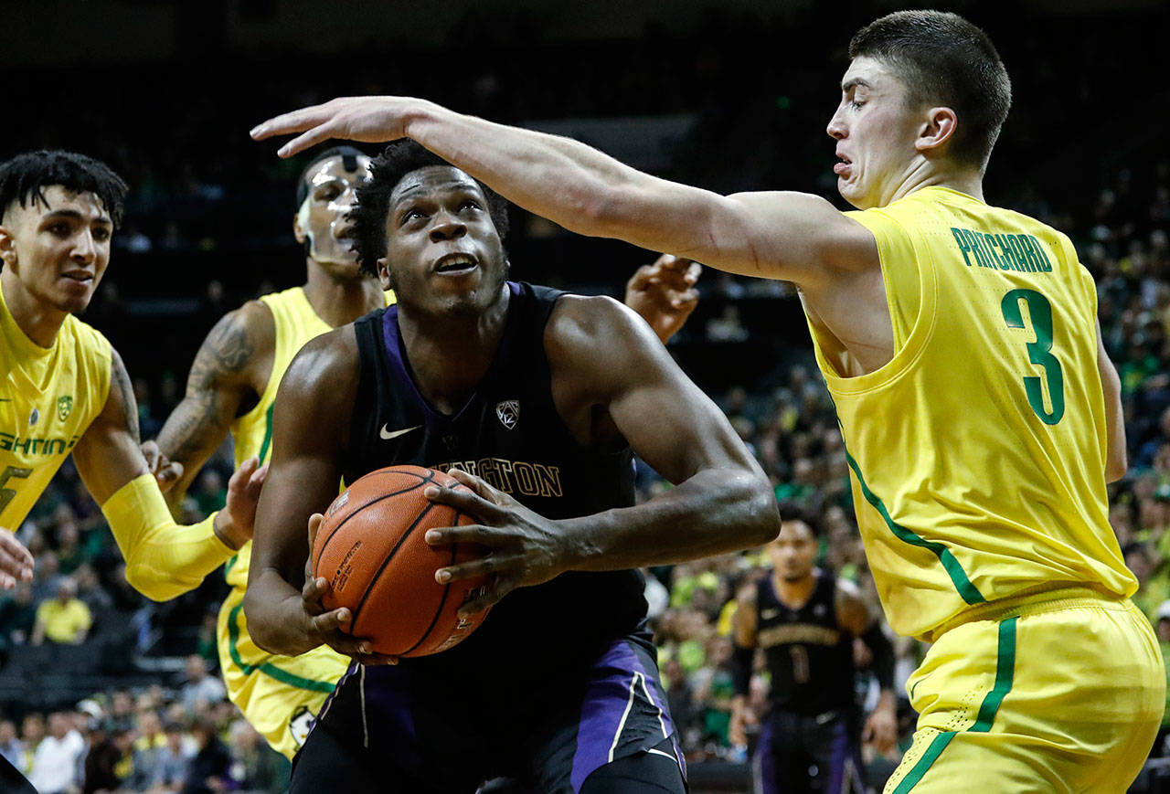 Washington forward Noah Dickerson (center) looks for a shot as Oregon guard Payton Pritchard (3) defends during a game on Jan. 24, 2019, in Eugene, Ore. (AP Photo/Thomas Boyd)