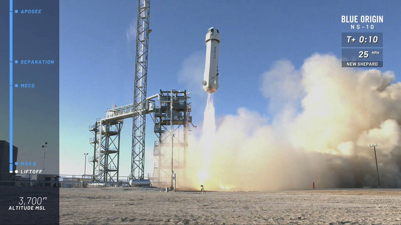 In this image from video, the New Shepard capsule and booster lifts off from the company’s site in west Texas. Jeff Bezos’ rocket company launched NASA experiments into space on the brief test flight. (Blue Origin via AP)