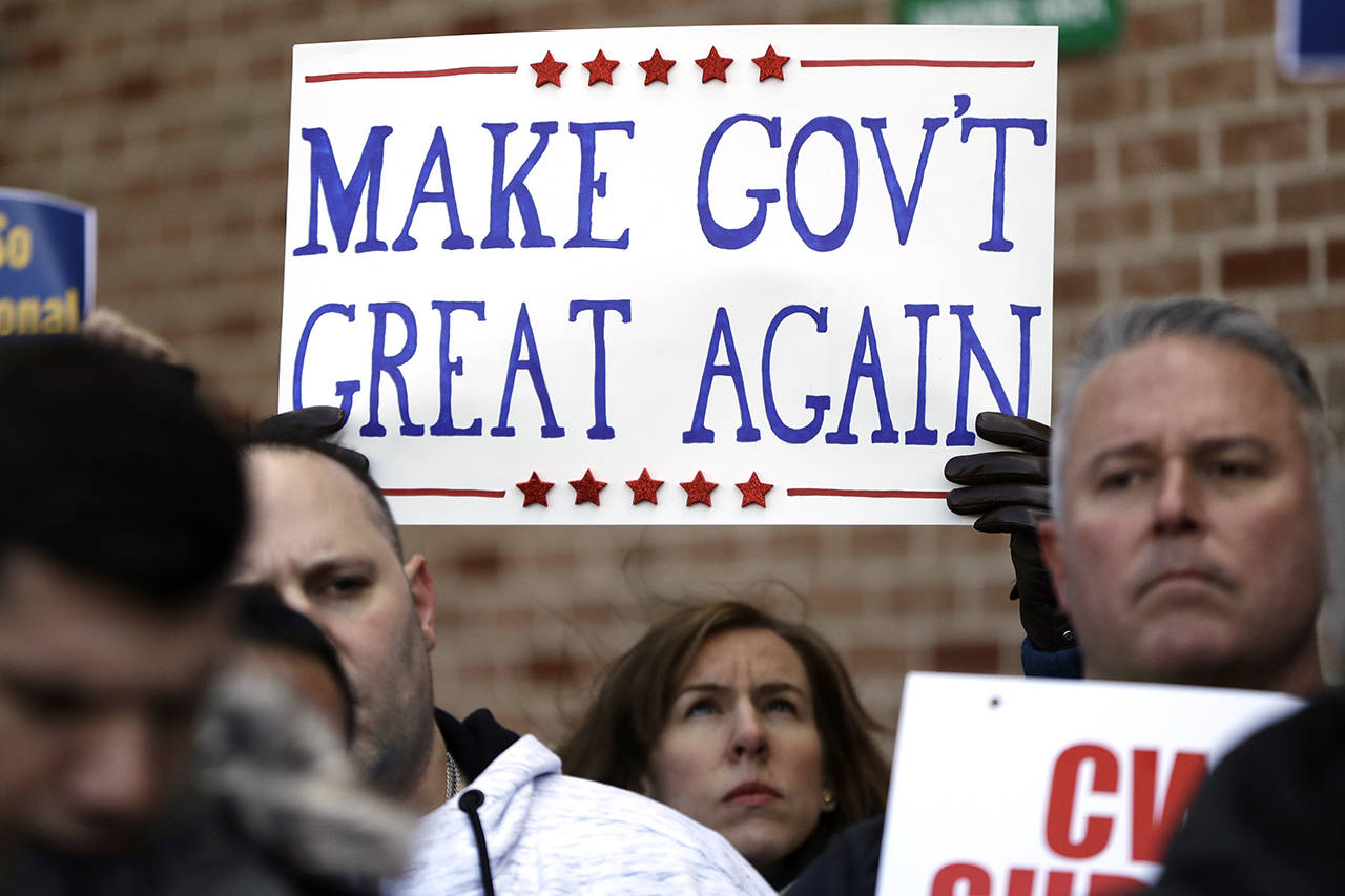 A demonstrator holds up a sign Friday, Jan. 25, during a rally by federal workers at the Philadelphia International Airport to end the government shutdown. (AP Photo/Matt Slocum)