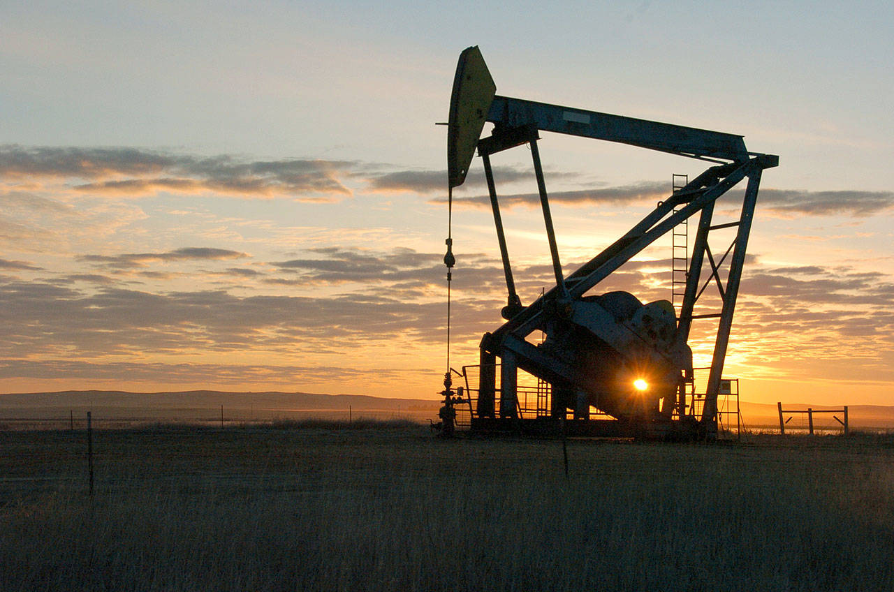 This Nov. 6, 2013, file photo shows a Whiting Petroleum Co. pump jack pulls crude oil from the Bakken region of the Northern Plains near Bainville, Mont. As the Trump administration rolls back environmental and safety rules for the U.S. energy sector, government projections show billions of dollars in savings reaped by companies will come at a steep cost: increased premature deaths and illnesses from air pollution, a jump in climate-warming emissions and more derailments of trains carrying explosive fuels. (AP Photo/Matthew Brown, File)