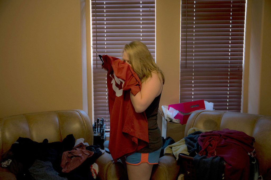 Brittaney Biggers, whose 20-year-old brother, Landon, died of a heroin overdose in 2017, smells a football jersey her brother used to wear in La Quinta, California. “It still smells like him,” she says. (AP Photo/Jae C. Hong)
