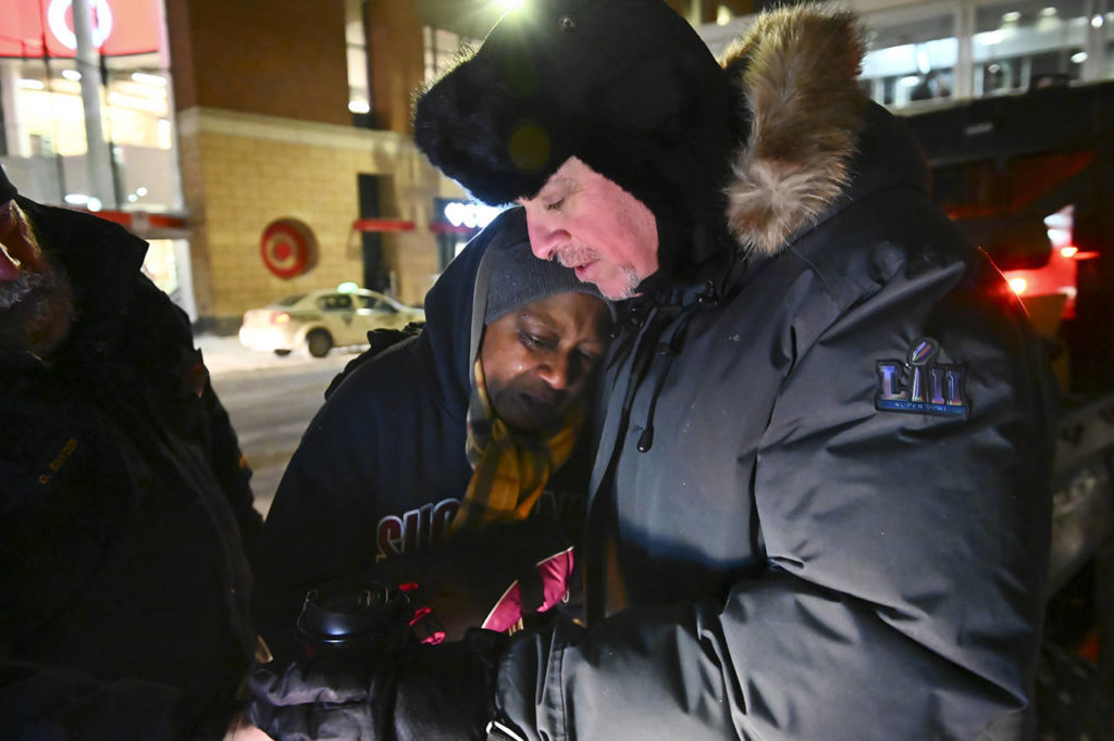Pastor John Steger, with Grace In The City church, embraces Jearline Cyrus, a homeless woman, in downtown Minneapolis on Tuesday while delivering cold-weather gear, hot chocolate and food. (Aaron Lavinsky/Star Tribune via AP)
