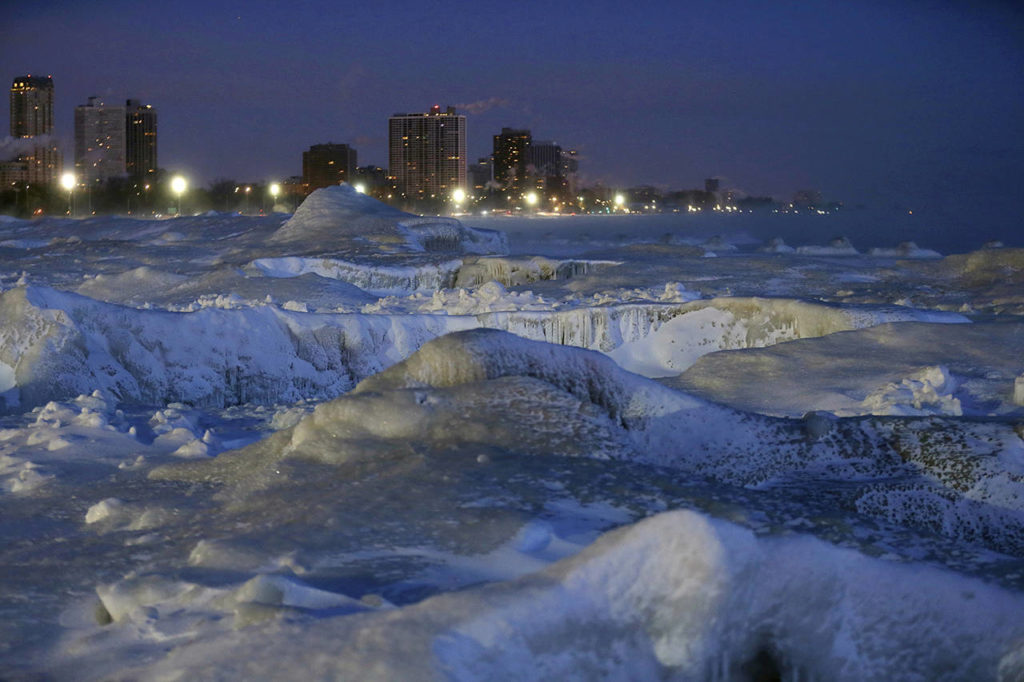Ice forms along the shore of Lake Michigan before sunrise Wednesday in Chicago. (AP Photo/Kiichiro Sato)
