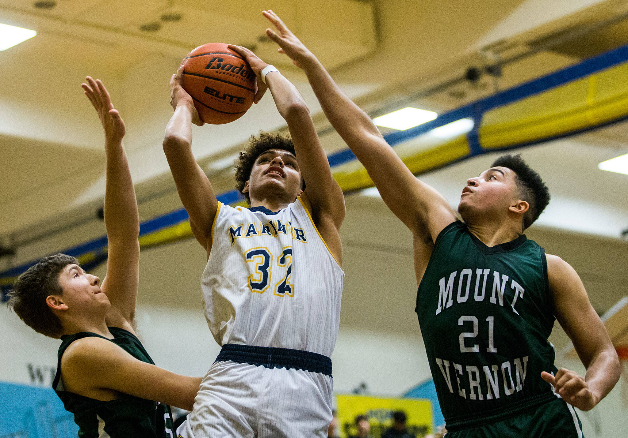 Mariner’s Henry Avra (center) goes up to the basket during a Wesco 4A boys basketball game against Mount Vernon on Wednesday at Mariner High School in Everett. (Olivia Vanni / The Herald)