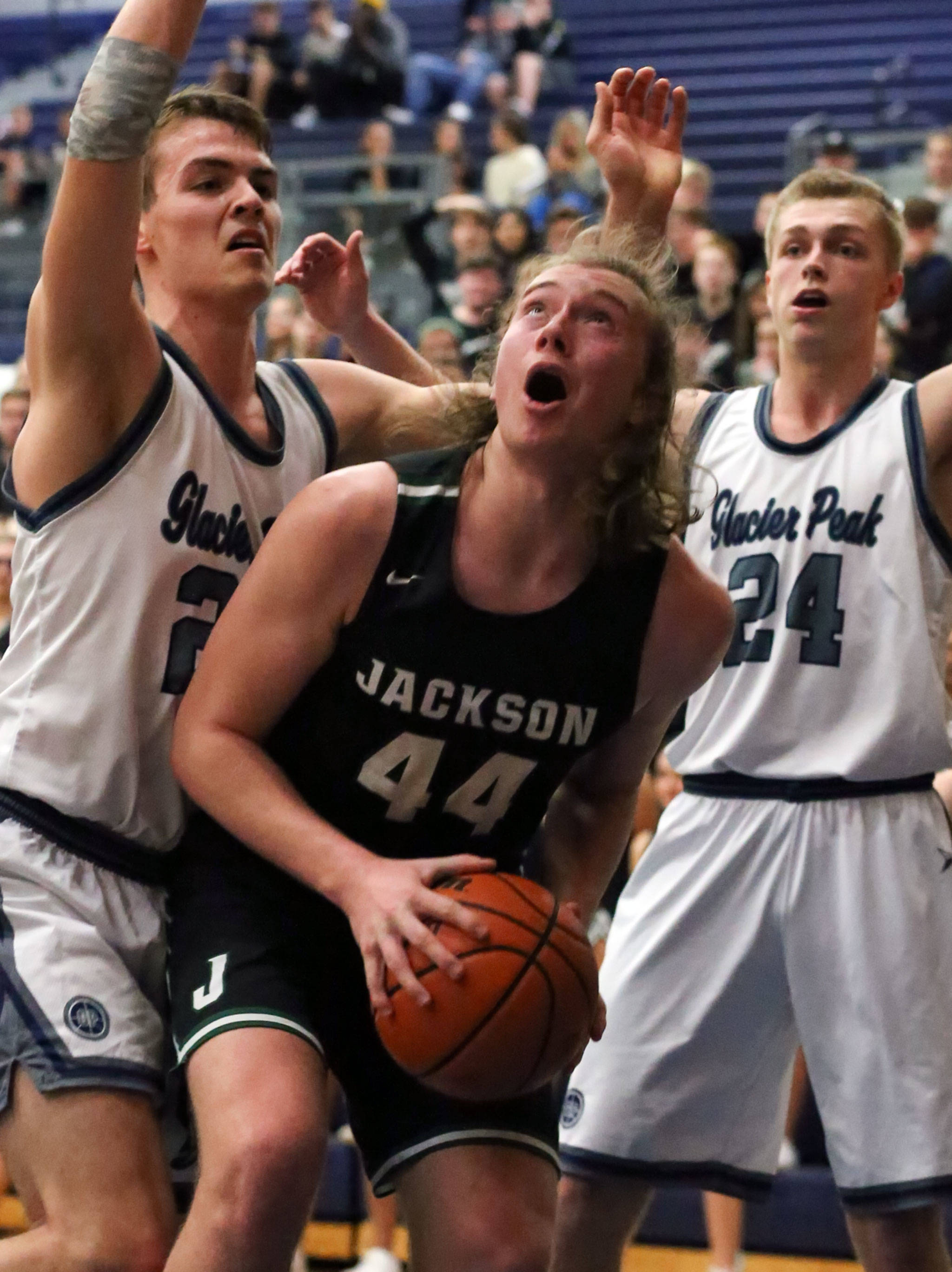 Jackson’s Joe Capponi (44) looks for a shot while Glacier Peak’s Noah Forman (left) and Glacier Peak’s Evan Mannes defend during a Wesco 4A boys basketball game Wednesday in Snohomish. Capponi and the Timberwolves fought past the Grizzlies for a 47-44 victory that ensured Jackson will have the conference’s top seed to the Wes-King 4A District tournament, which begins next weekend. (Kevin Clark / The Herald)
